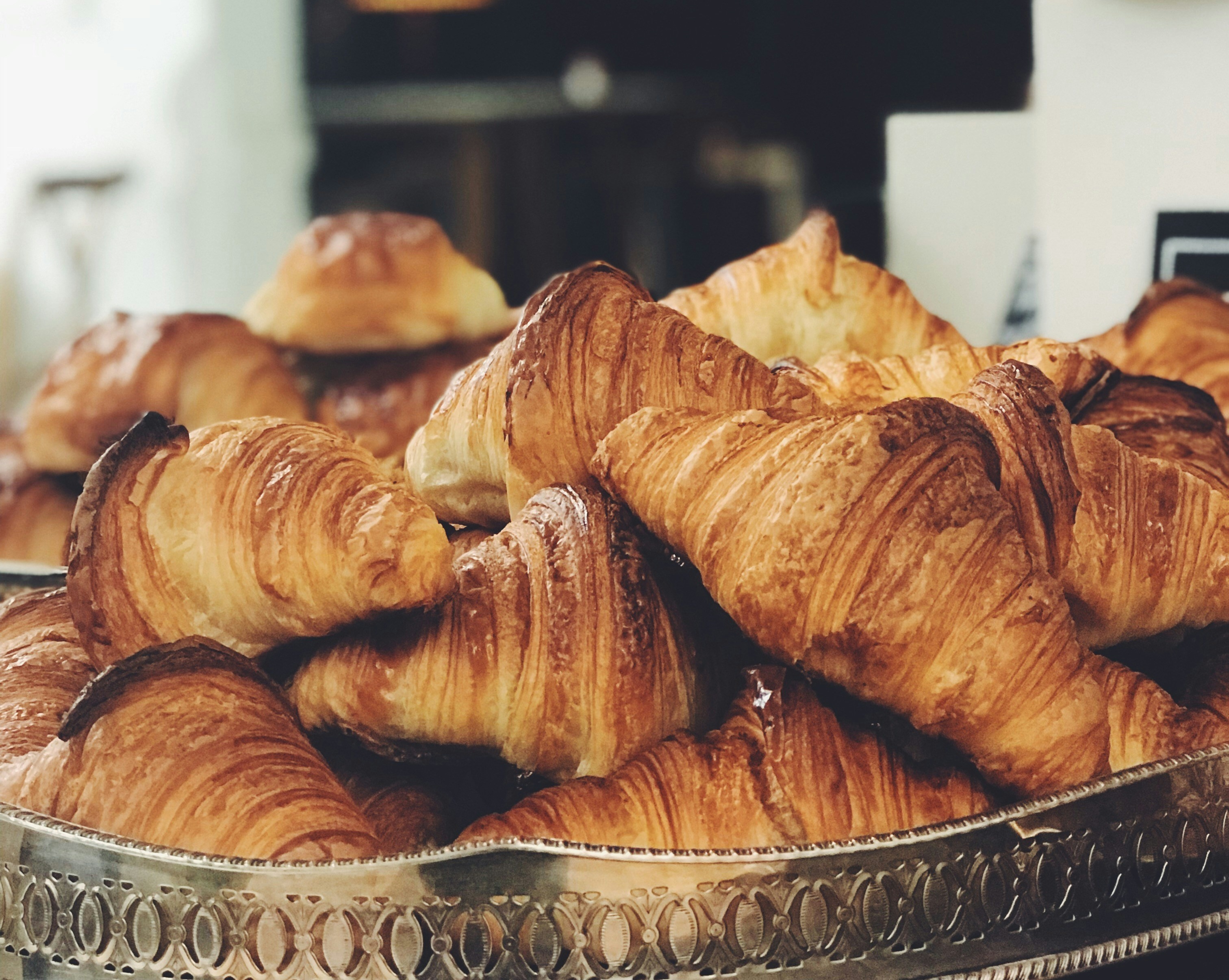 A pile of croissants on a silver tray